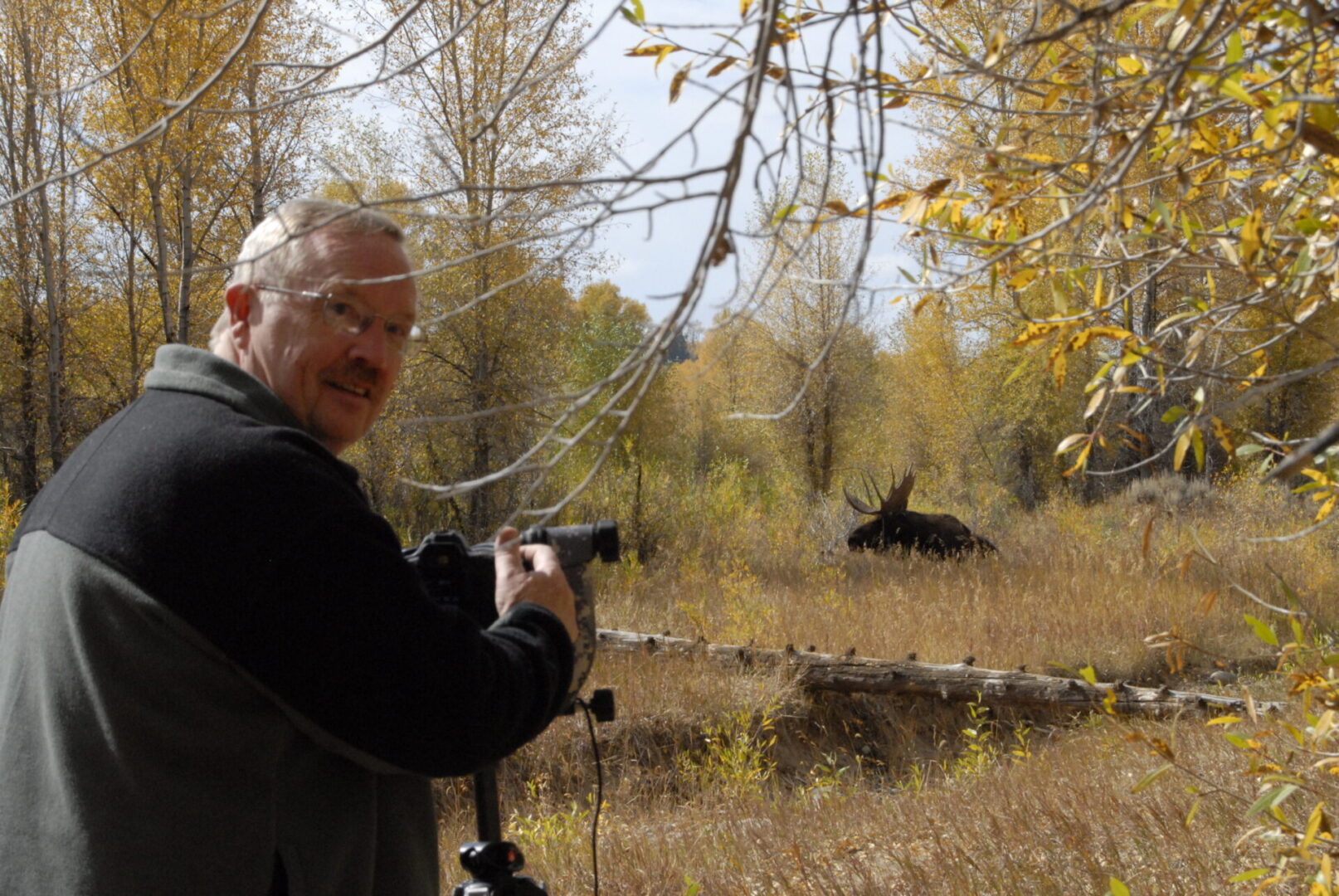 A man holding a camera in the woods